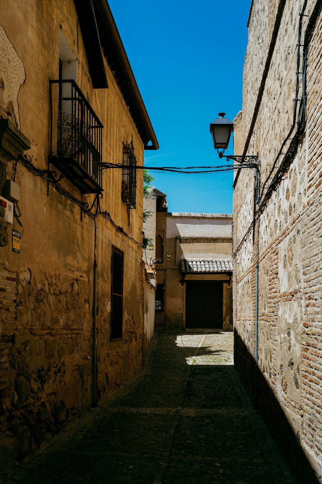 Narrow cobblestone street with hanging lanterns in a Chilean old town